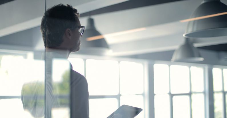 Solutions - Formal man with tablet giving presentation in office